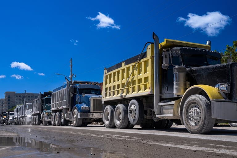 Row of dump trucks on the street waiting to load