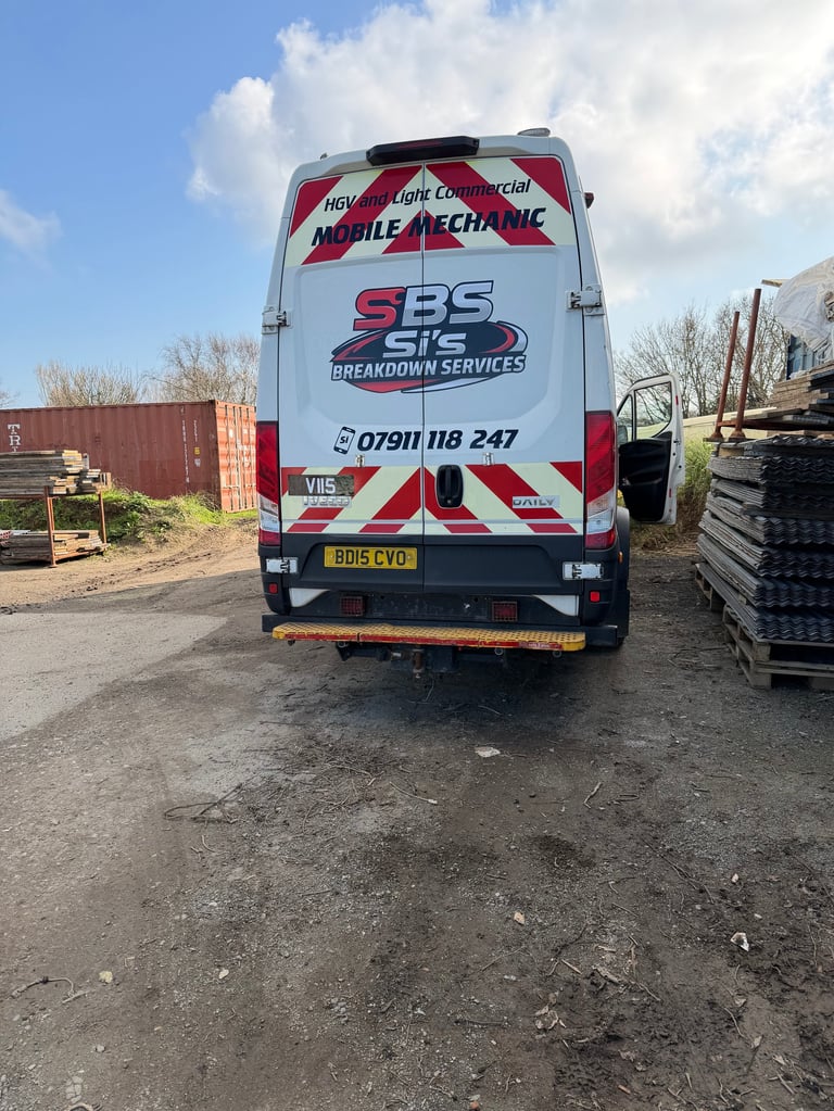 Rear view of a white and red mobile mechanic van with SBS Breakdown Services branding and contact number parked at a yard